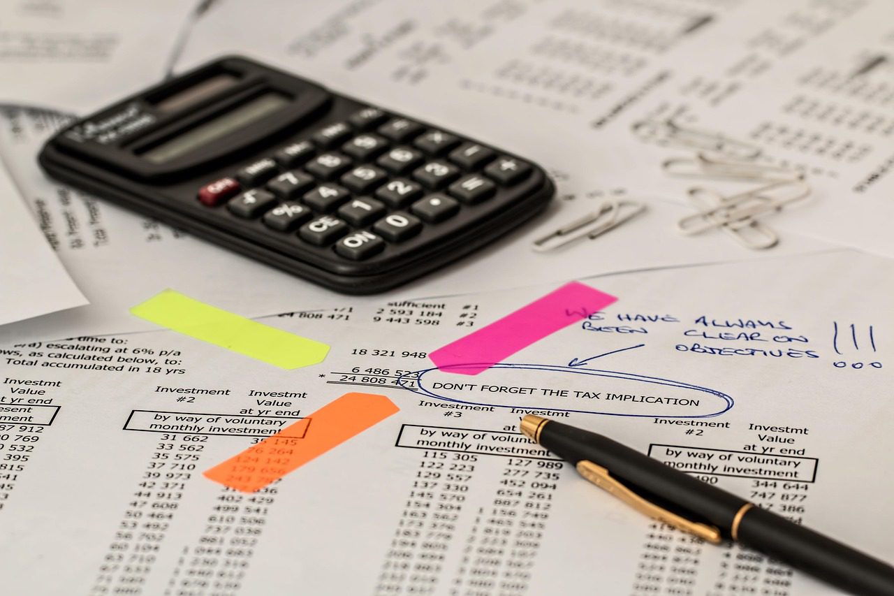 Calculadora y planilla sobre un escritorio para calcular el costo laboral de una pyme